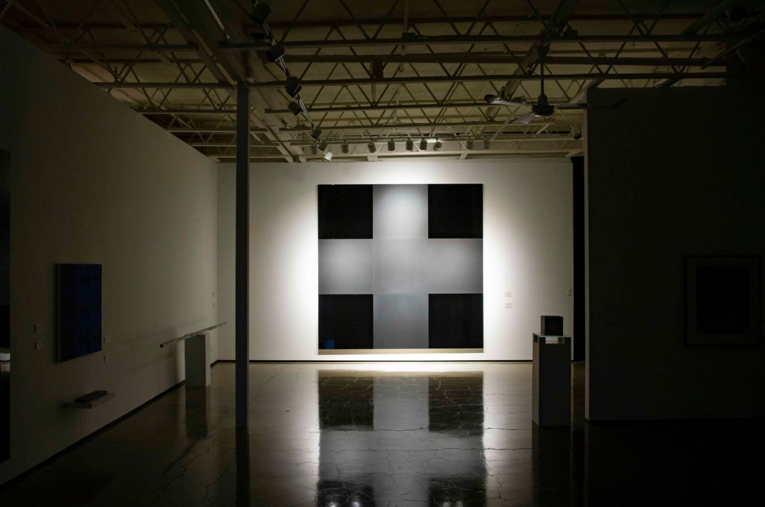 Track lighting illuminating artwork in a gallery.