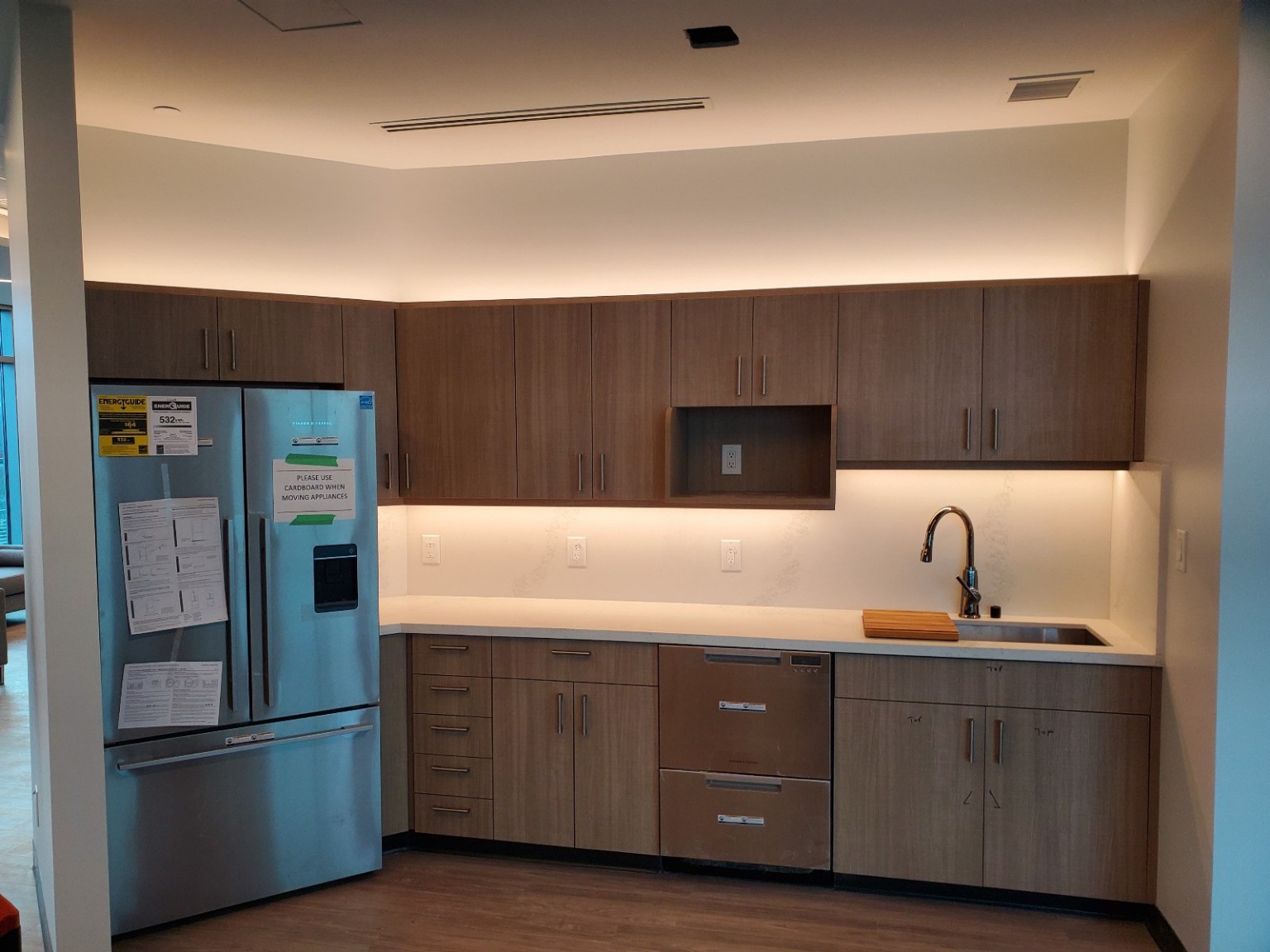 Wood cabinetry with under-cabinet and above-cabinet lighting during fit-out